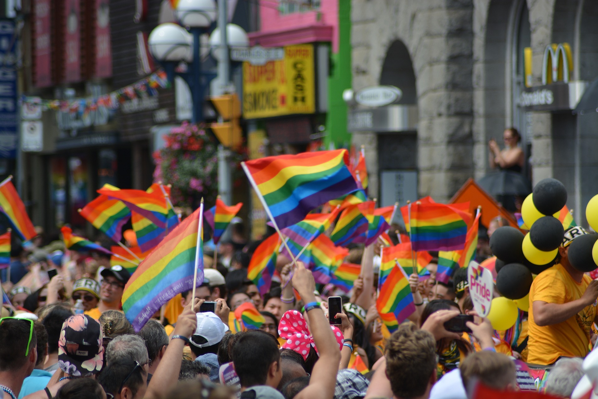 People holding rainbow flags during a Pride parade.
