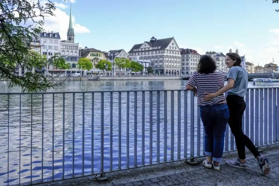 Two girls smiling on the Limmat River in Zurich.