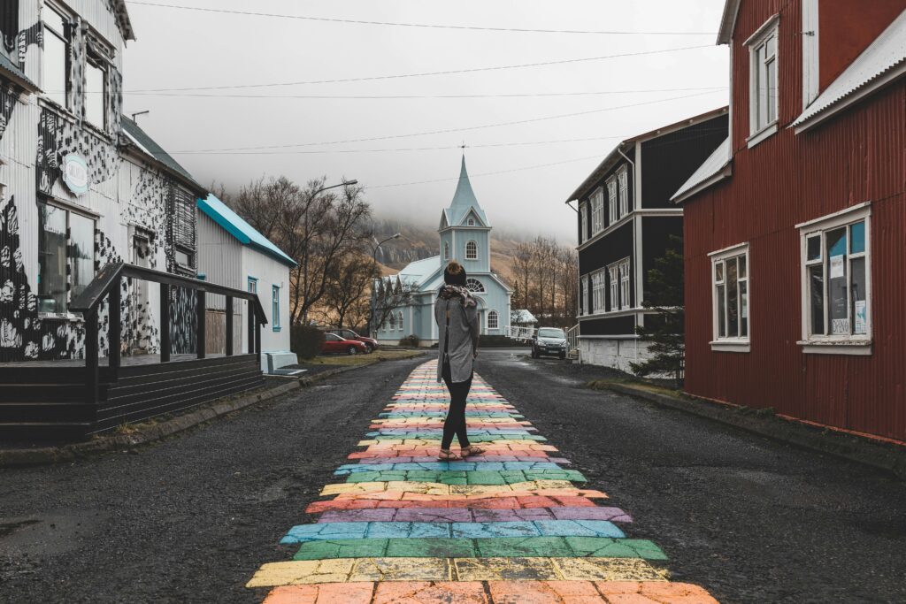A woman standing in Iceland rainbow street.